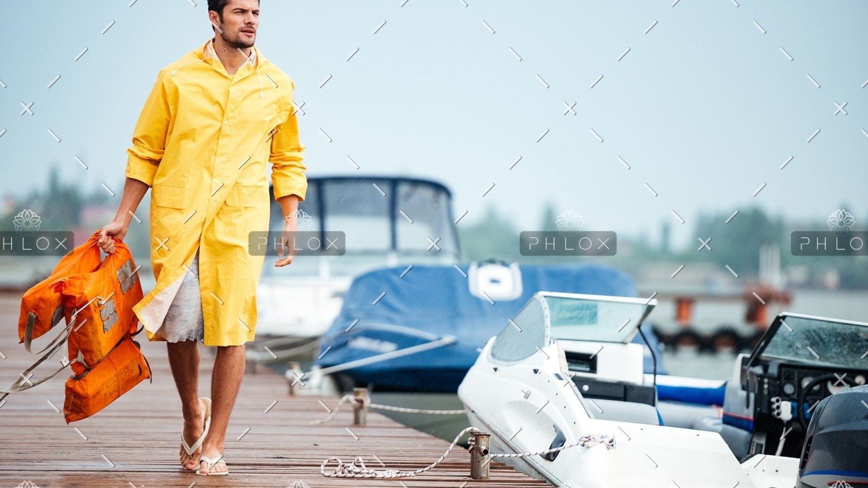 demo-attachment-32-sailor-in-yellow-cloak-at-the-pier-holding-life-PX7M94D